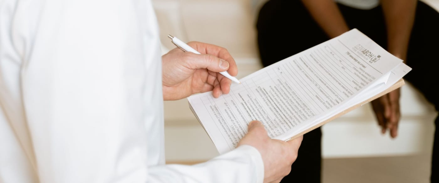 A doctor at Dr. D Signature Clinic noting down a personalised treatment plan during a consultation